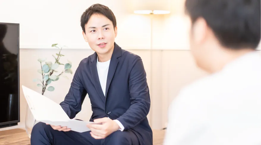 資料を手に持って対話する住宅アドバイザーの写真。失敗しない会社選びの基準を解説するイメージ。